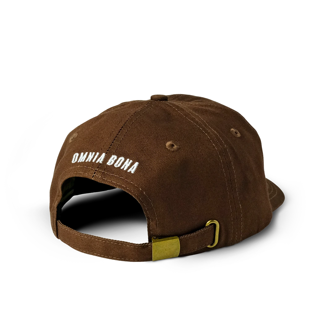 Rear view of brown Omnia Bona baseball cap featuring white embroidered logo and brass adjustable strap