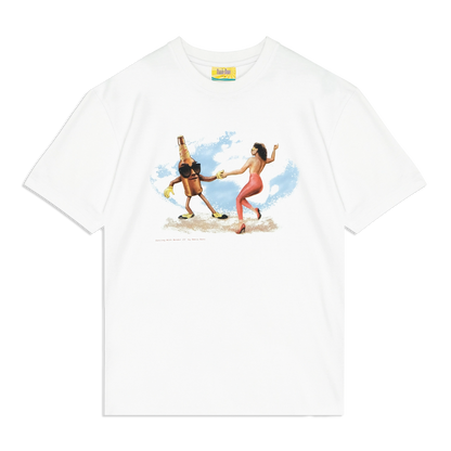 White graphic T-shirt featuring a vintage-style illustration of a dancing woman in red pants and high heels holding hands with an anthropomorphic beer bottle wearing gloves and shoes, set against a blue sky background